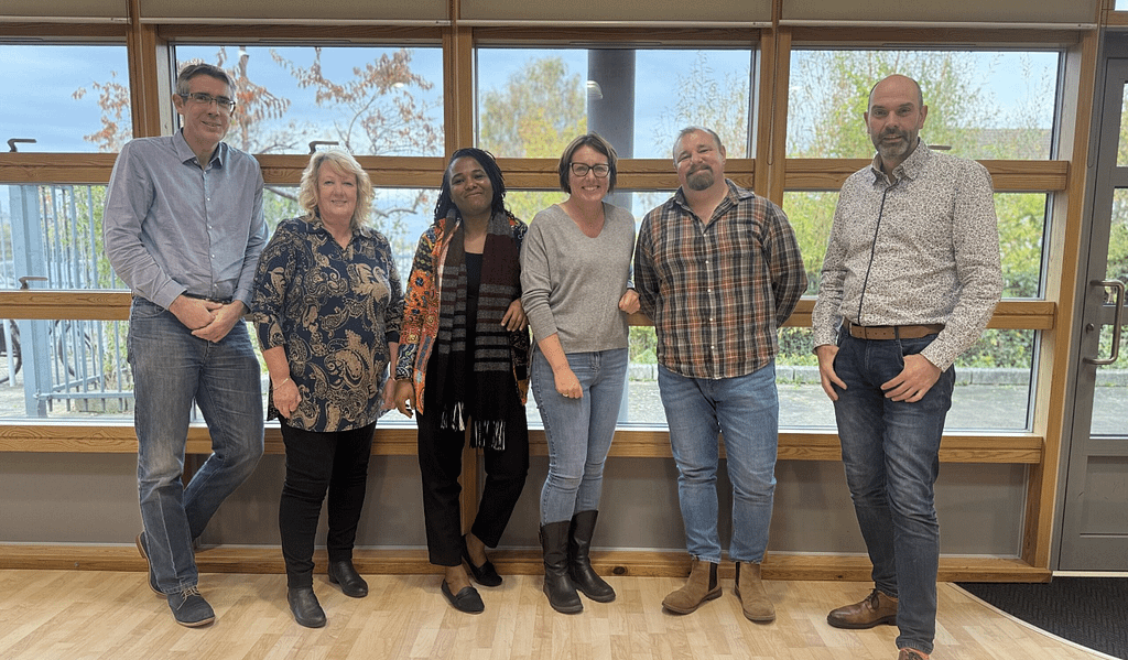 The Avantix team standing in a line in front of a window